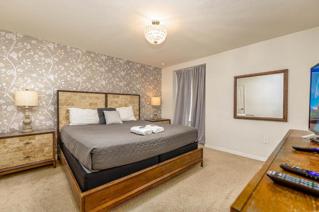 een slaapkamer met een bed, een bureau en een spiegel bij TVPM-8916AL WWS townhouse in Kissimmee