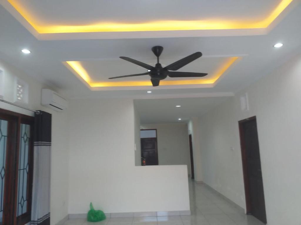 a ceiling with a black ceiling fan on a room at Juicezzy Home in Panji