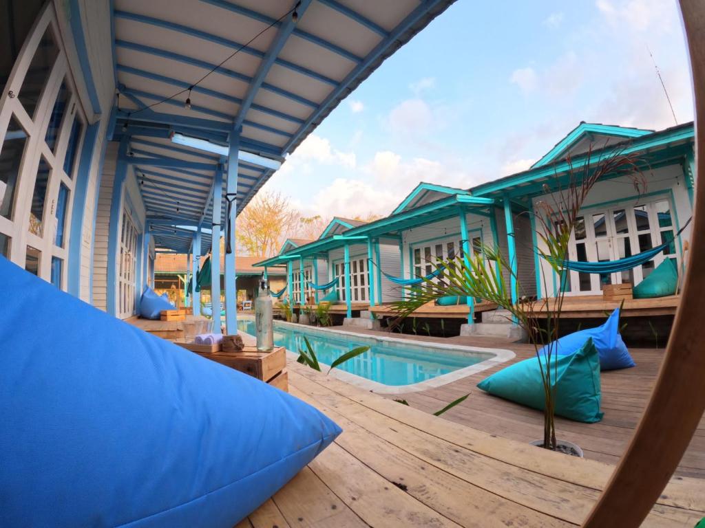 un complexe avec une piscine et un hamac dans l'établissement Casa Kapuas, à Gili Trawangan