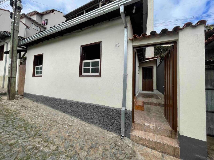 Casa em Ouro Preto في أورو بريتو: مبنى ابيض بباب من جهه