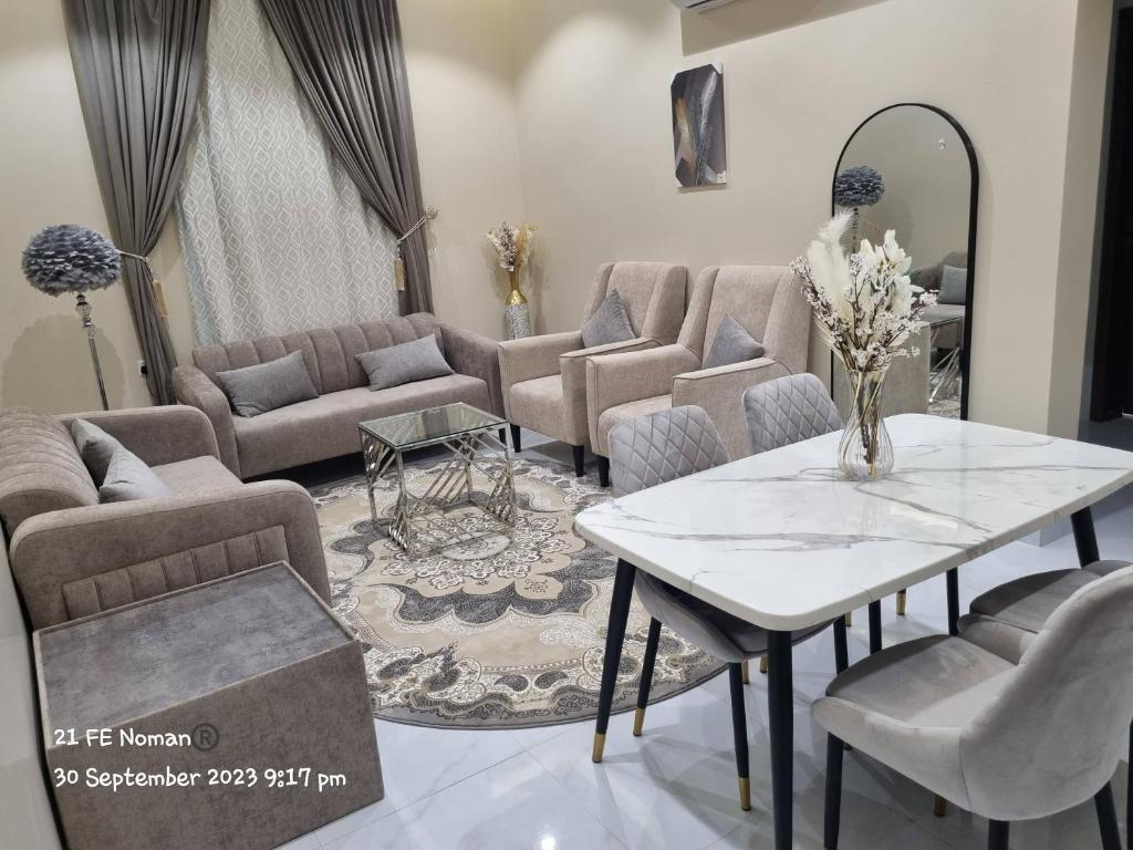 ein Wohnzimmer mit Sofas, einem Tisch und Stühlen in der Unterkunft أجنحة فندقية مفروشة عوائل فقط in Bisha
