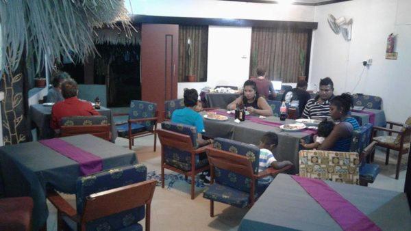 um grupo de pessoas sentadas à mesa numa sala em Outback Retreat/Hotel, Ba Fiji em Tonge