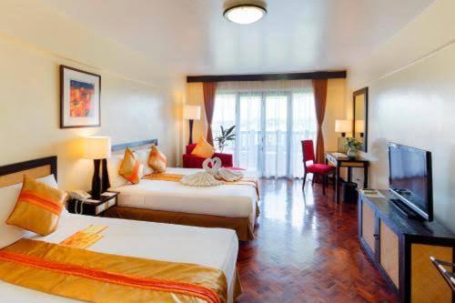 Habitación de hotel con 2 camas y TV de pantalla plana. en Keira 208, Alta Vista De Boracay, en Boracay
