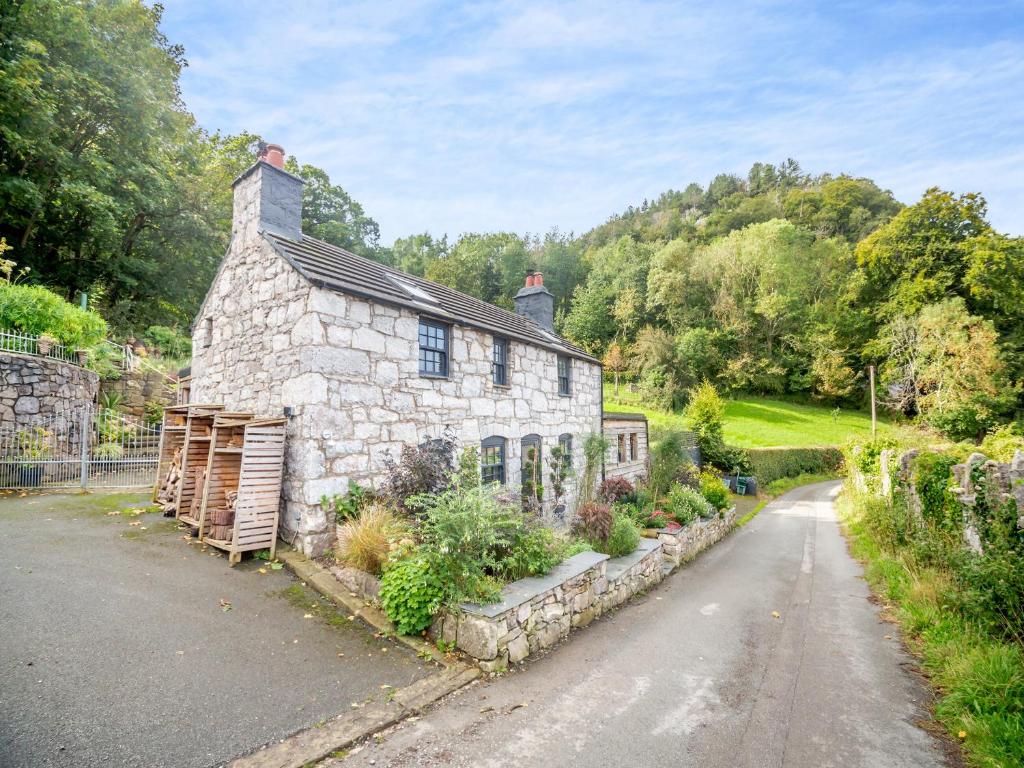 an old stone house on the side of a road at Yr Allt in Abergele