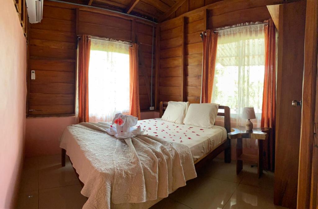 a bedroom with a bed in a room with wooden walls at Cabaña ITZE in Fortuna
