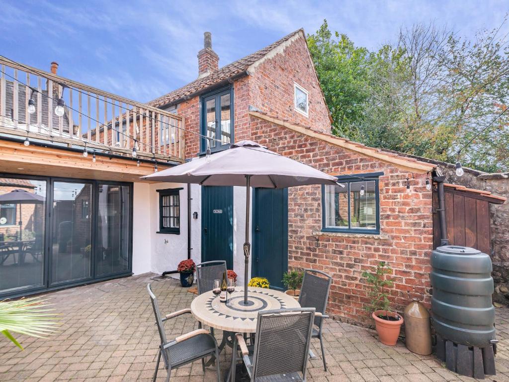 a patio with an umbrella and a table and chairs at The Stables - Uk44766 in Ripon