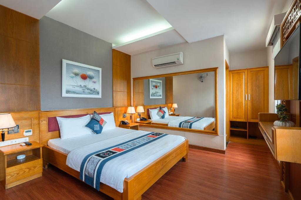 una camera d'albergo con due letti e uno specchio di Anh Dao Hotel ad Ho Chi Minh