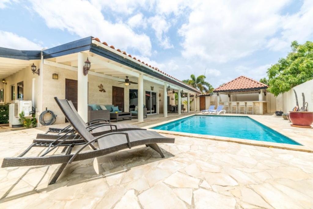 eine Villa mit einem Pool und einem Haus in der Unterkunft Casa Luna in Palm-Eagle Beach