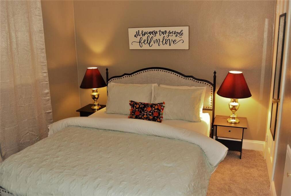 um quarto com uma grande cama branca e 2 candeeiros em The Red 6 em Grand Forks