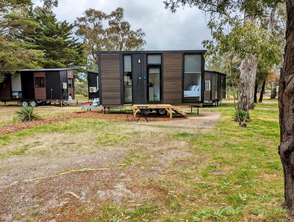 a tiny house with a picnic table in a yard at Tiny House 18 at Grampians Edge in Dadswells Bridge