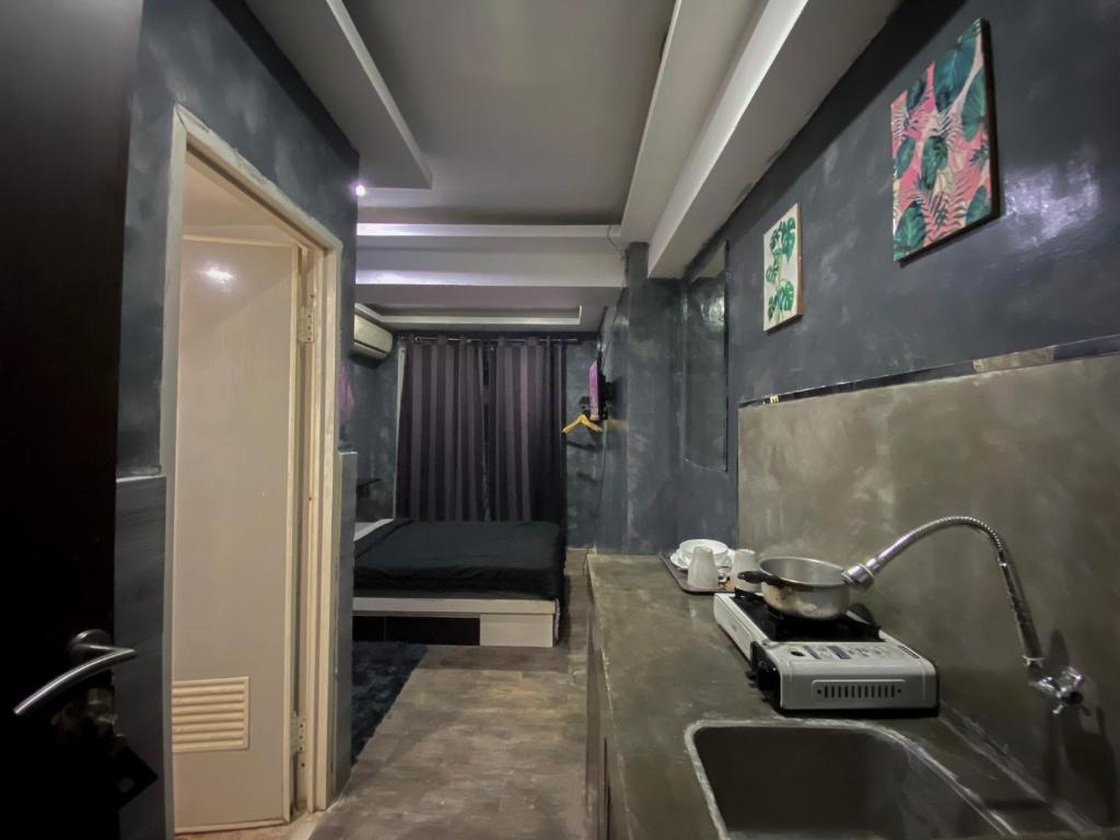 baño con lavabo y habitación con cama en Jarrdin Apartment by RumahKu, en Bandung