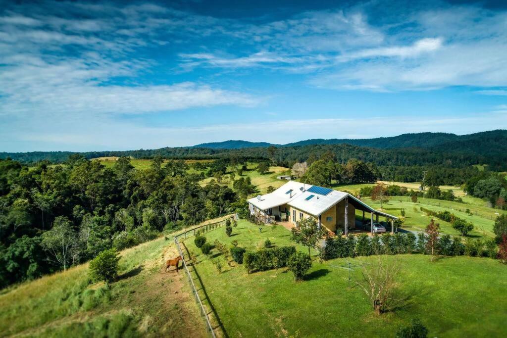 an aerial view of a house on a grassy hill at The Tree House Bellingen in Thora