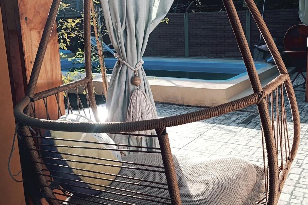 - une balançoire avec hamac et piscine en arrière-plan dans l'établissement Casa Olivia- Alojamiento con piscina - Aeropuerto Ezeiza, à Ezeiza