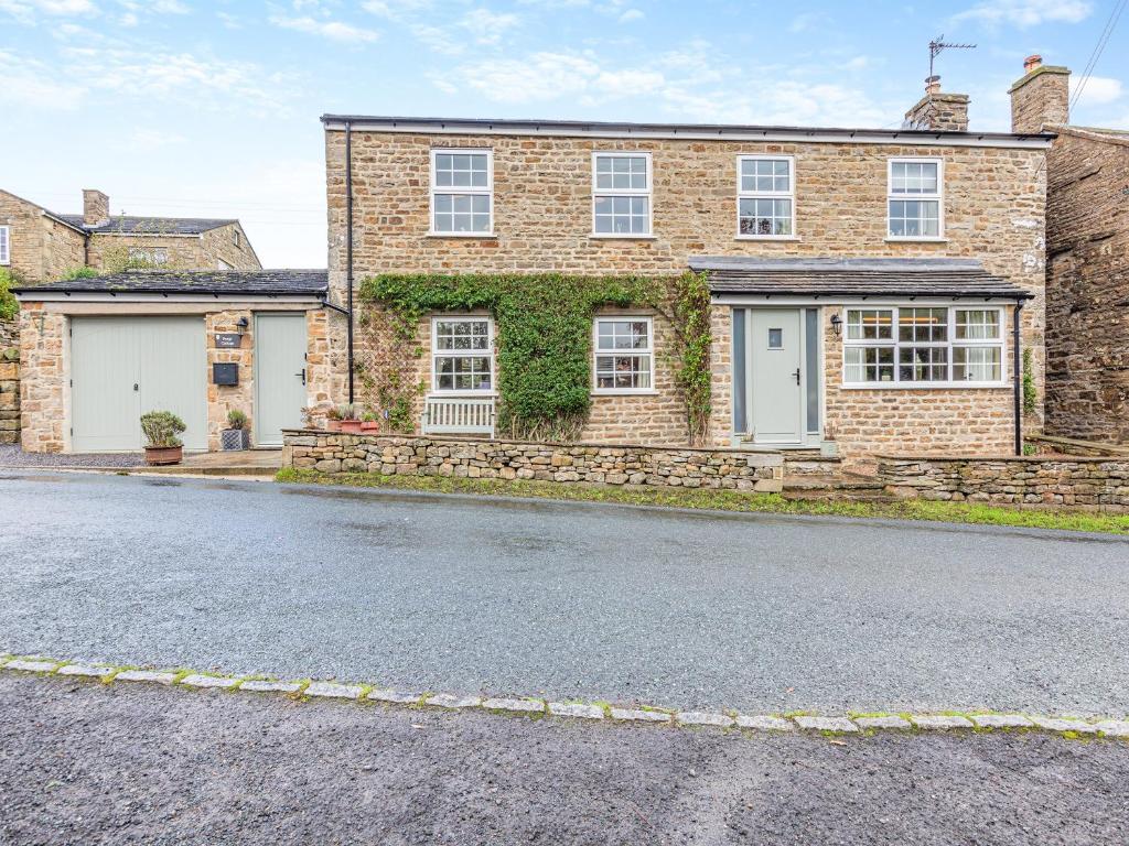 a brick house with a cobblestone street at Forge Cottage in Carlton