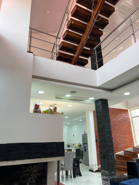 Casa de Campo Guayllabamba في كيتو: غرفة معيشة مع درج في مبنى