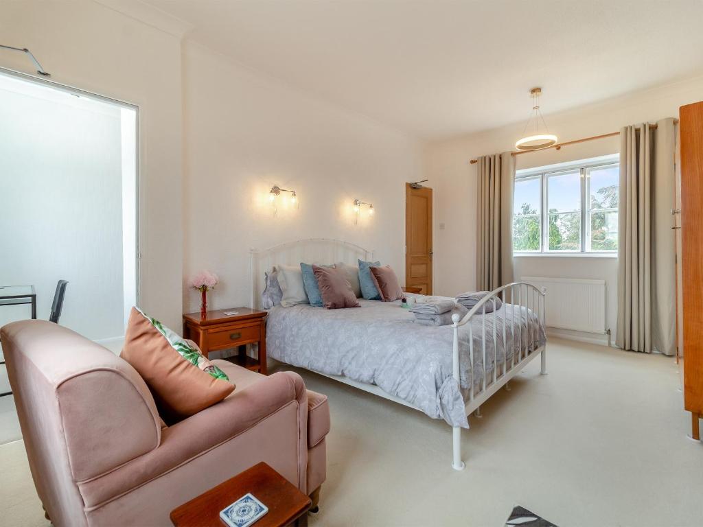 um quarto com uma cama, uma cadeira e um sofá em Coconut Mill em Lavenham