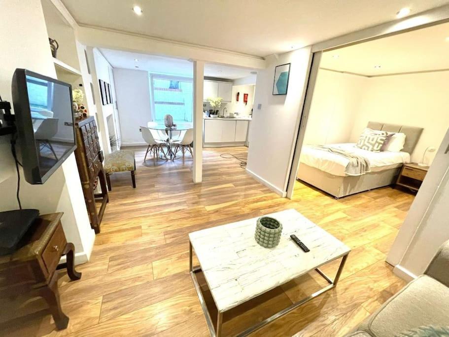 ein Wohnzimmer mit einem Bett und einem Tisch in der Unterkunft HISTORICAL BUILDING / Cozy Basement Apt / Central in Cambridge