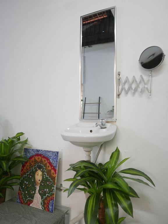 a bathroom with a sink and a mirror and a painting at little heritage home in George Town