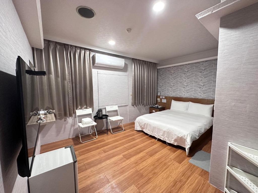 um quarto com uma cama e uma televisão em 町宿溫泉旅館 em Jiaoxi