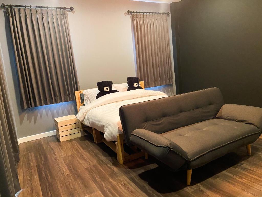 - une chambre avec un lit, un canapé et une chaise dans l'établissement Black Bear House Resort & Onsen, à Chiang Dao