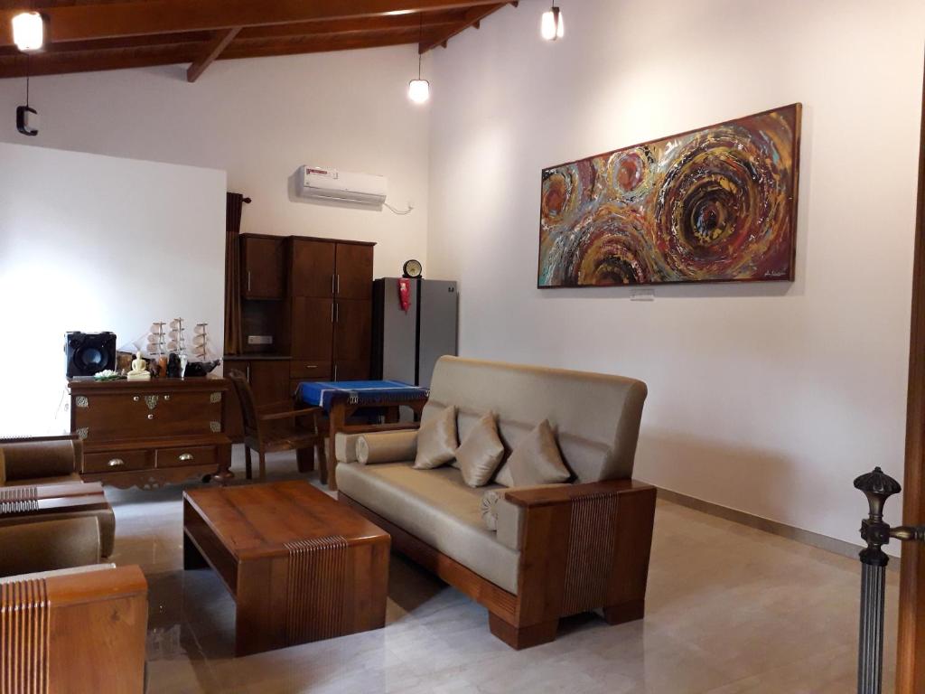 ein Wohnzimmer mit einem Sofa und einem Gemälde an der Wand in der Unterkunft Luxury Villa with BB Free WI-FI in Bentota
