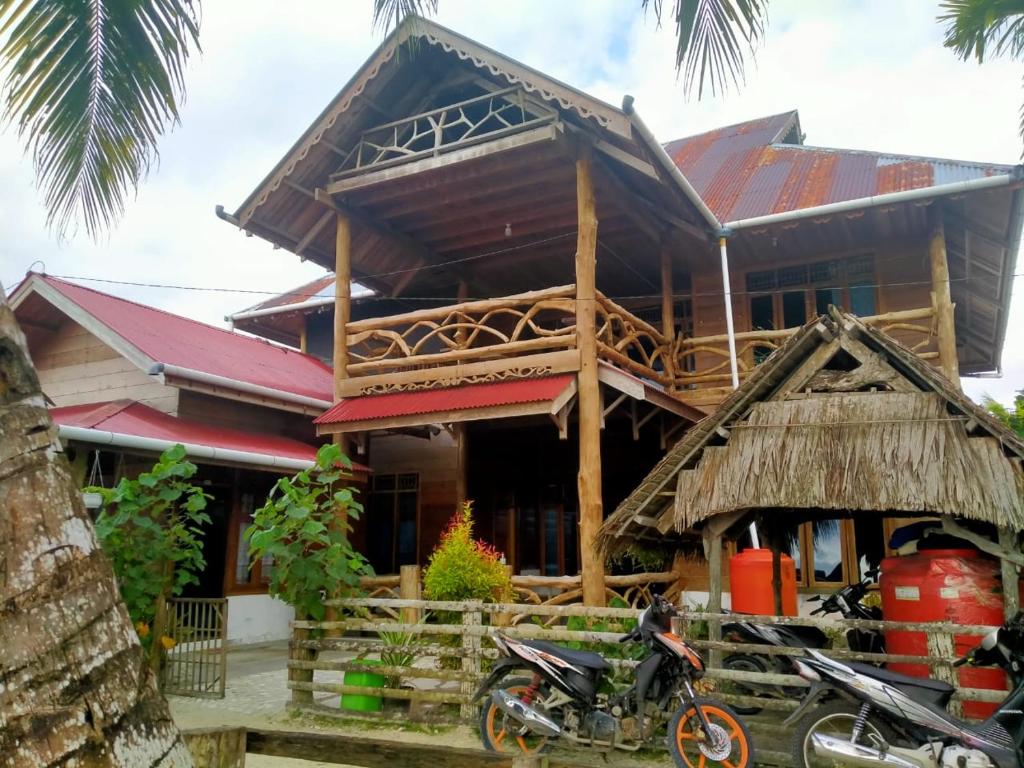 una casa con una motocicleta estacionada frente a ella en Kutnalek Surf Camp Siberut Mentawai front Beach,Green Village,front Wave for surfing, en Masokut