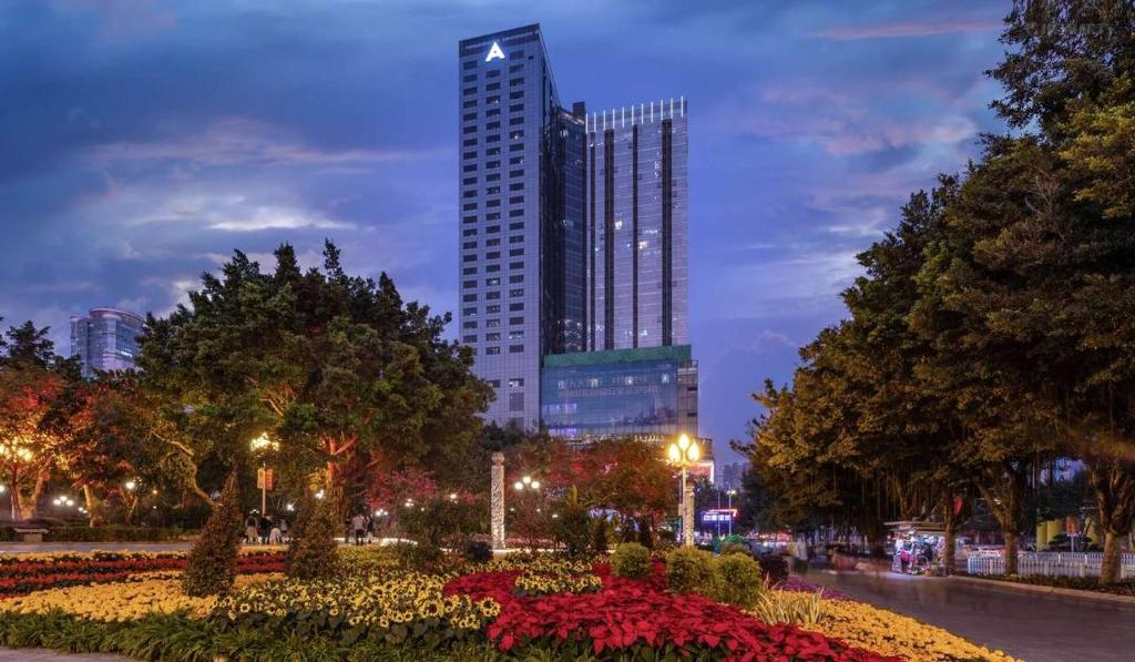 Un palazzo alto in una città di notte con fiori di Yoyo Apartment Jiedeng Metropolis Branch, Beijing Road a Canton