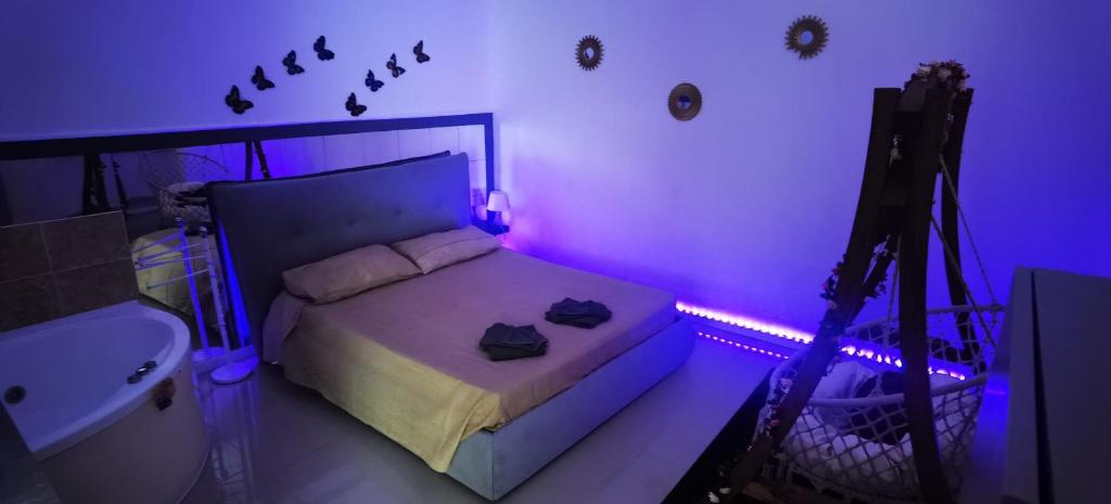 een slaapkamer met een bed en een camera in een paarse kamer bij Dolce Appartamento al centro di Civitavecchia in Civitavecchia