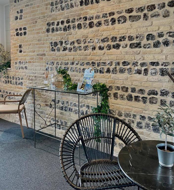 a table and a chair in a room with a brick wall at LA TOUR AUX CRABES près de la plage in Dieppe
