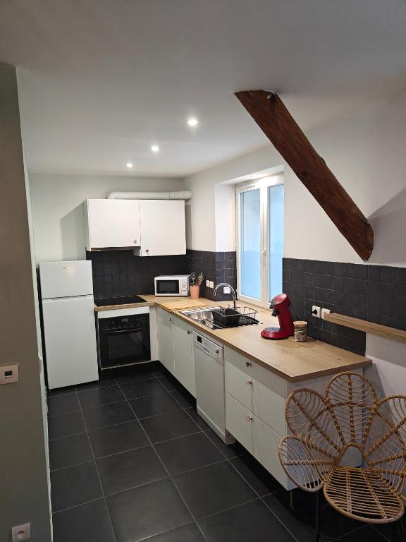 La cuisine est équipée de placards blancs, d'un évier et d'un comptoir. dans l'établissement Villa Delalo, à Barcelonnette