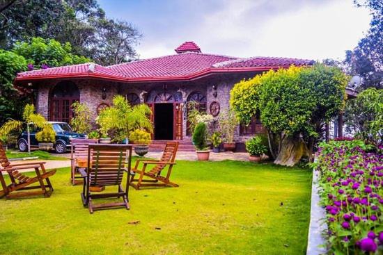 a house with chairs and a table in a yard at MF Holiday Bungalow in Bandarawela