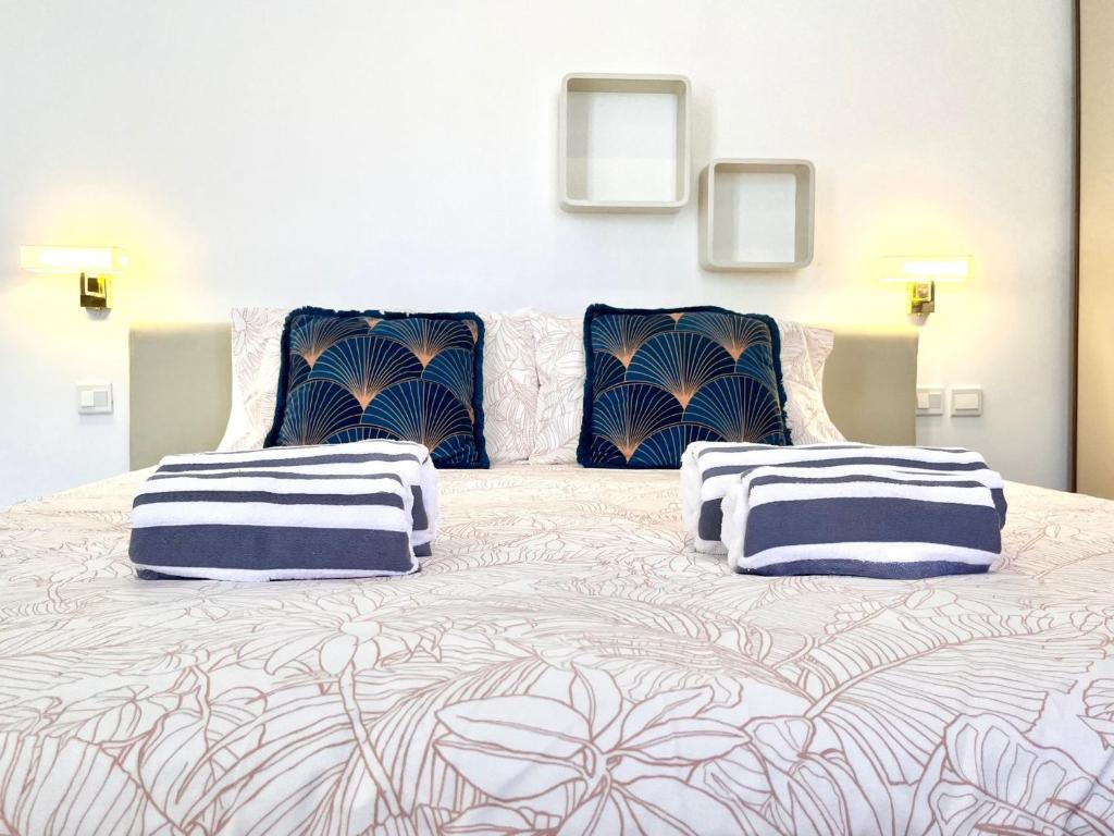 a large bed with blue and white pillows on it at Bright Bookworm's Haven in Sliema
