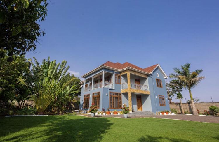 a large blue house with a lawn in front of it at Lerai X Desty in Arusha