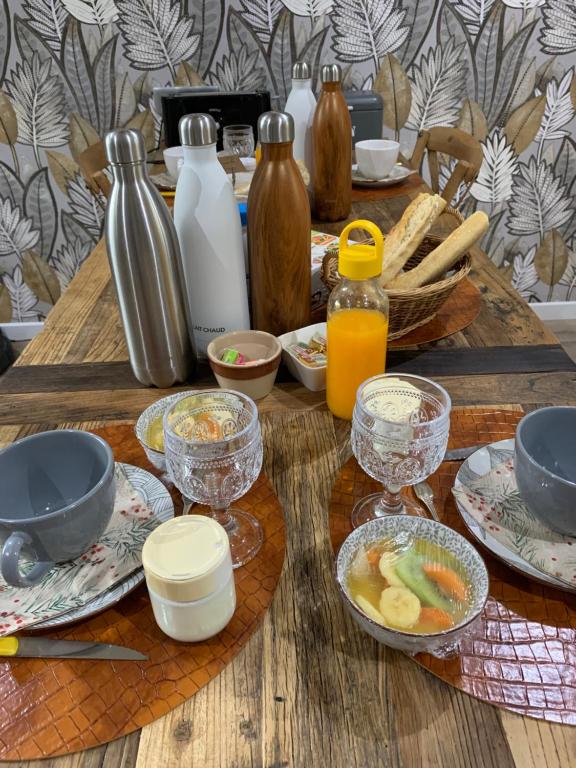 una mesa de madera cubierta con platos de comida y bebida en Bocage et Coquillage, en Gouville-sur-Mer
