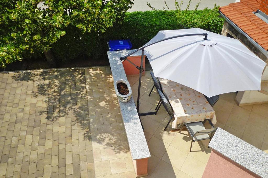 parasol siedzący obok krzesła i stołu w obiekcie Apartment PINK in Starigrad Paklenica only 200 m from the sea w mieście Starigrad-Paklenica