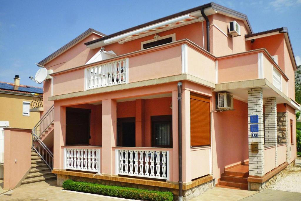 różowy dom z balkonem na ulicy w obiekcie Apartment PINK in Starigrad Paklenica only 200 m from the sea w mieście Starigrad-Paklenica