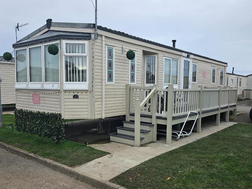 a tiny house with a porch and a staircase at Rhuddlan Salty Smiles in Rhuddlan