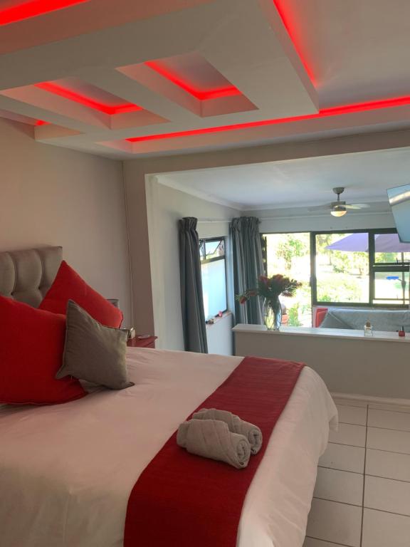 a bedroom with a large bed with a red ceiling at Footprints Self Catering Solar No Loadshedding in Lanseria