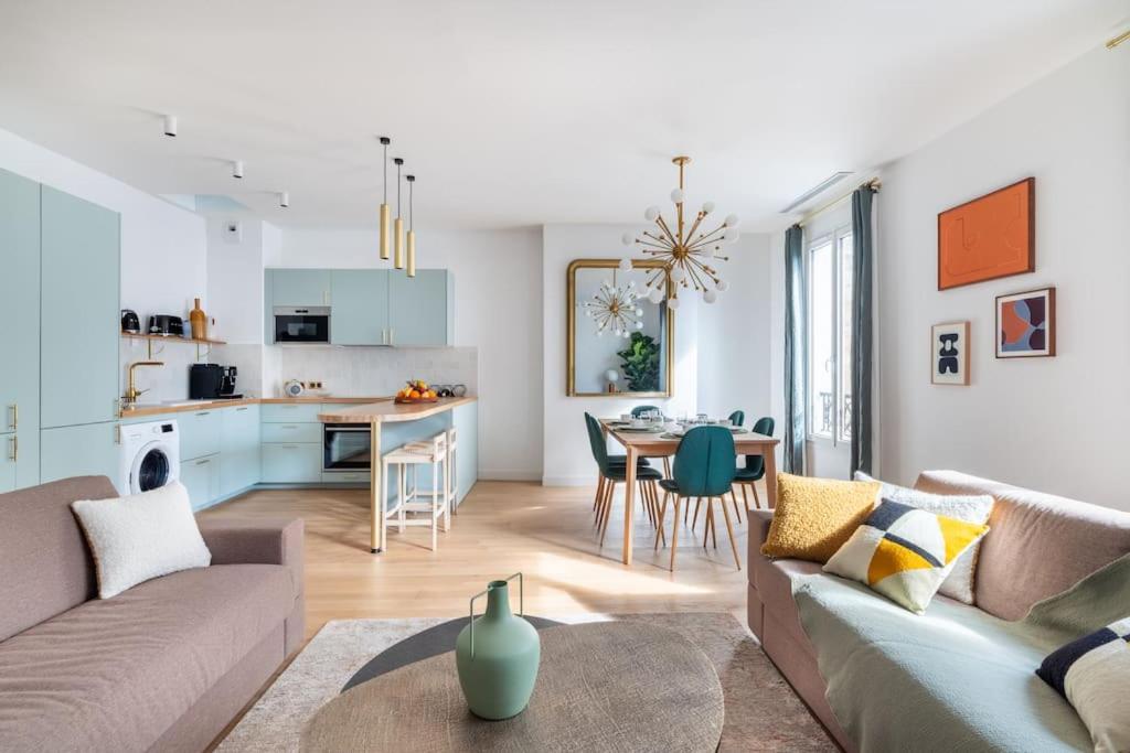 un salon avec un canapé et une table et une cuisine dans l'établissement Rare, center, luxury apartment with roof view, à Paris