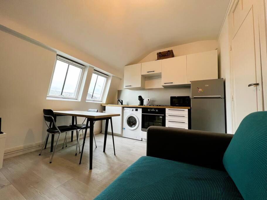 ein Wohnzimmer mit einem Tisch und einer Küche in der Unterkunft Villa Beauregard in Mers-les-Bains