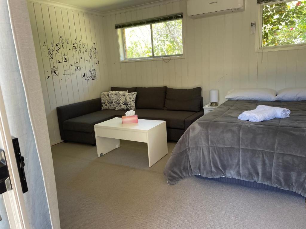 een kleine slaapkamer met een bed en een bank bij Canberra Hospital Locum Welcome in Harman