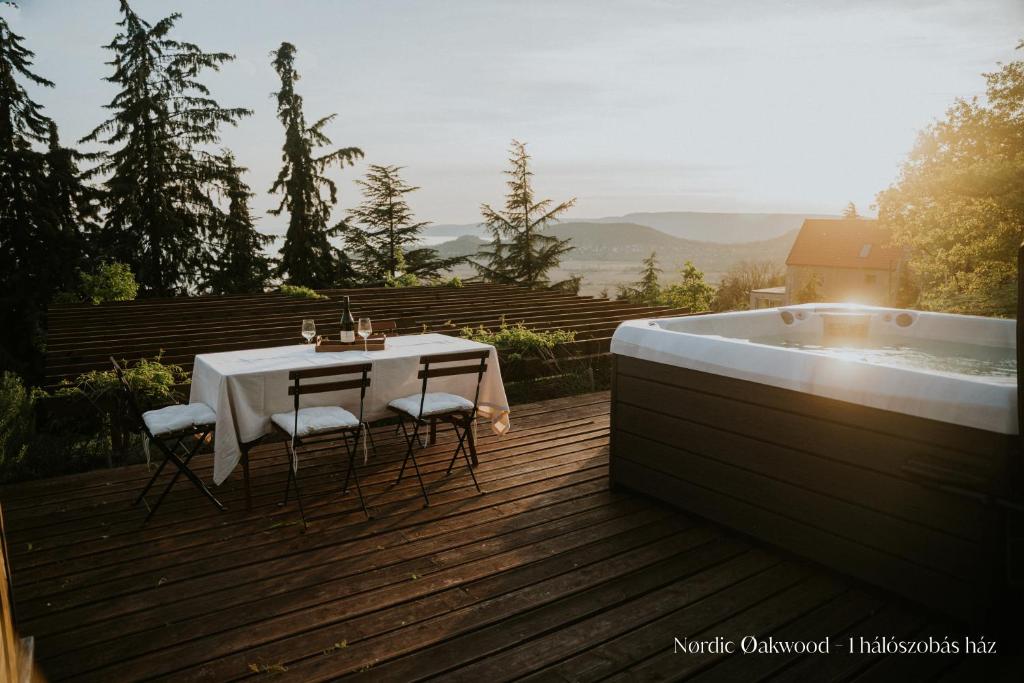 a table and chairs on a deck next to a bath tub at Nørdic Balatøn Badacsony in Badacsonytördemic