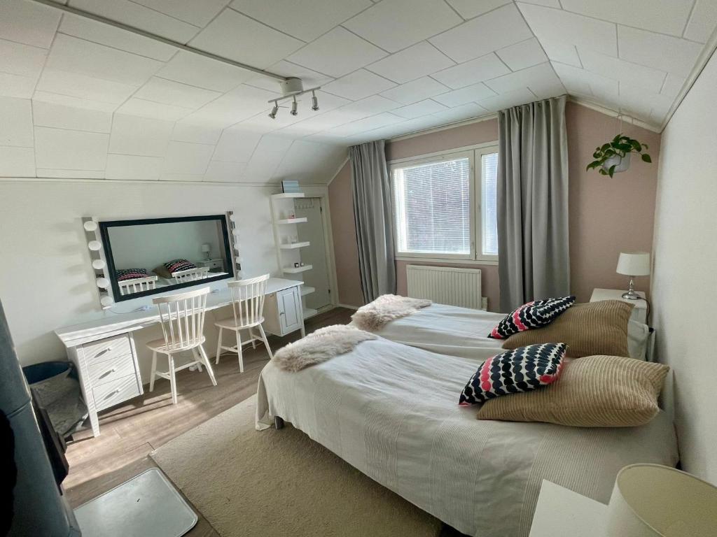 a bedroom with two beds and a table and a television at Villa Juuris in Rovaniemi