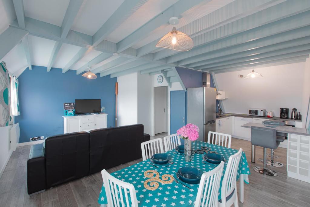 ein Esszimmer mit einem Tisch und Stühlen sowie eine Küche in der Unterkunft Gîte de la Marina dans la presqu'île de Lézardrieux in Lézardrieux