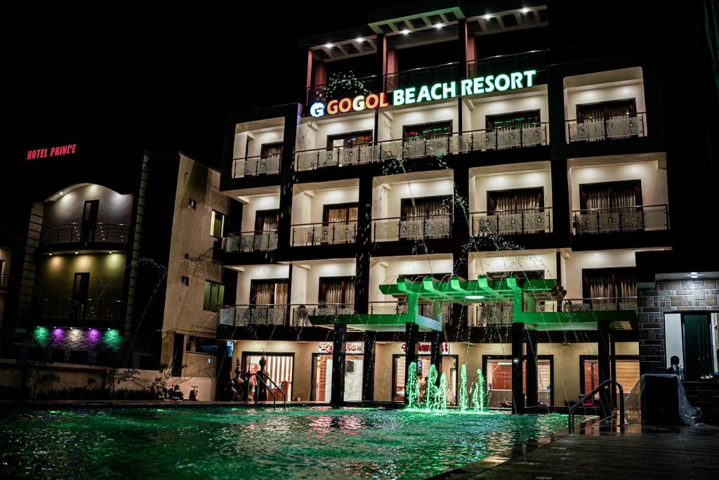 a building with a fountain in front of it at night at Gogol Beach Resort in Mandarmoni