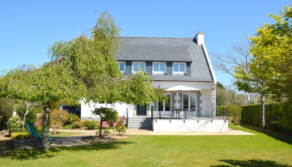 ein weißes Haus mit einem Hof in der Unterkunft Villa Mana - Sejour entre calme et modernite pour 6 in La Forêt-Fouesnant