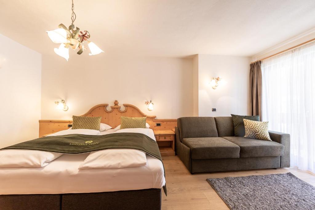 セストにあるB&B Grüne Laterne - Lanterna Verdeのベッドルーム(ベッド1台、ソファ付)