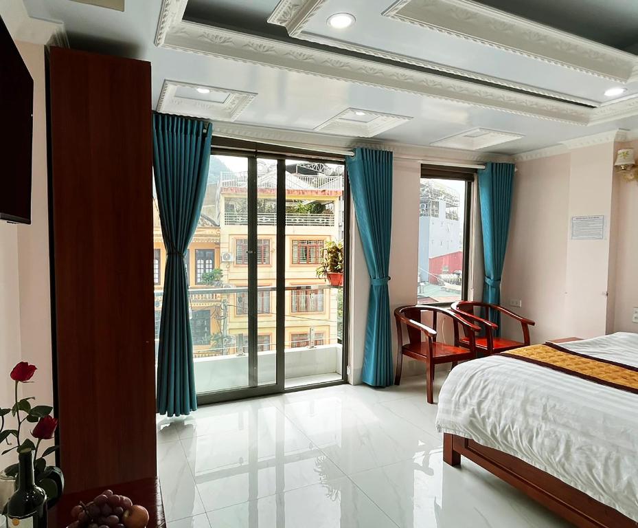 - une chambre avec un lit et une grande fenêtre dans l'établissement Quoc Tuan Hotel Sapa, à Sa Pa