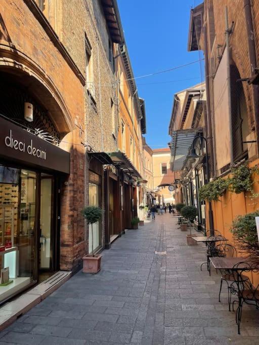 an empty street with tables and chairs in an alley at Cairoli Apartment in Ravenna