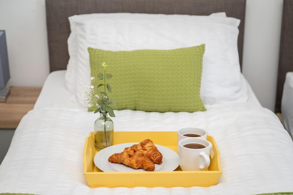 a tray with a plate of food on a bed at Spacious Home In The Heart of West Yorkshire in Brighouse